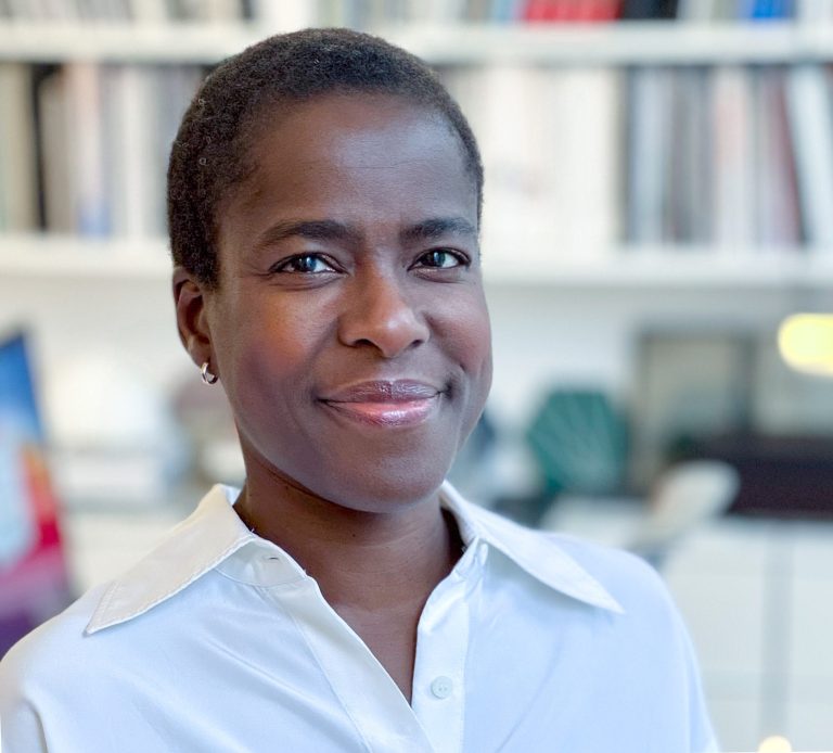 Lara Akeju, Executive Coach Lara Akeju headshot, standing in workplace